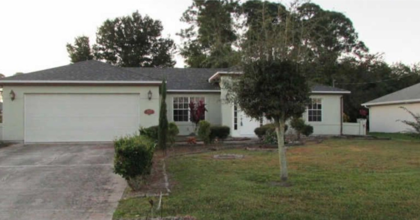 Single-story home with faded pale exterior before painting
