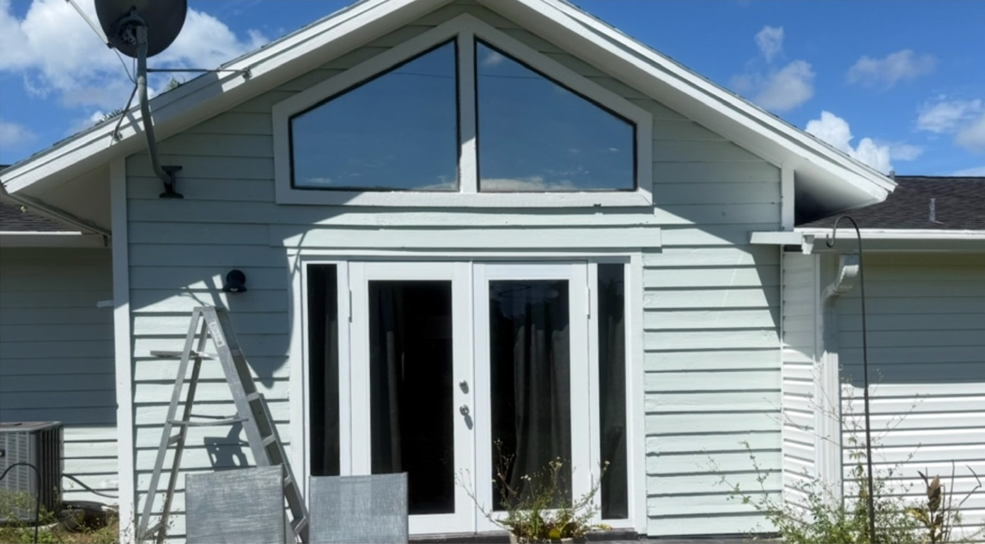 Light-colored siding and patio doors before exterior painting