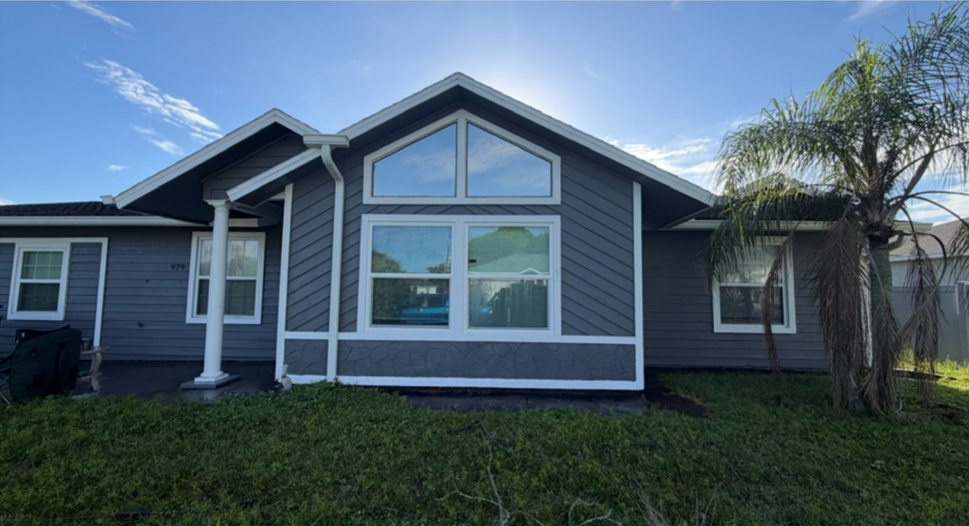 House with freshly painted dark siding and crisp white window trim